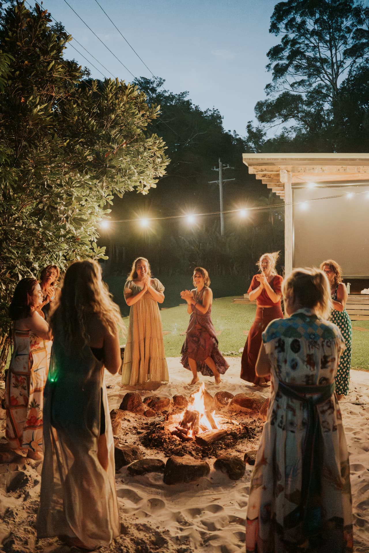 Women gathered around the fire pit at dusk