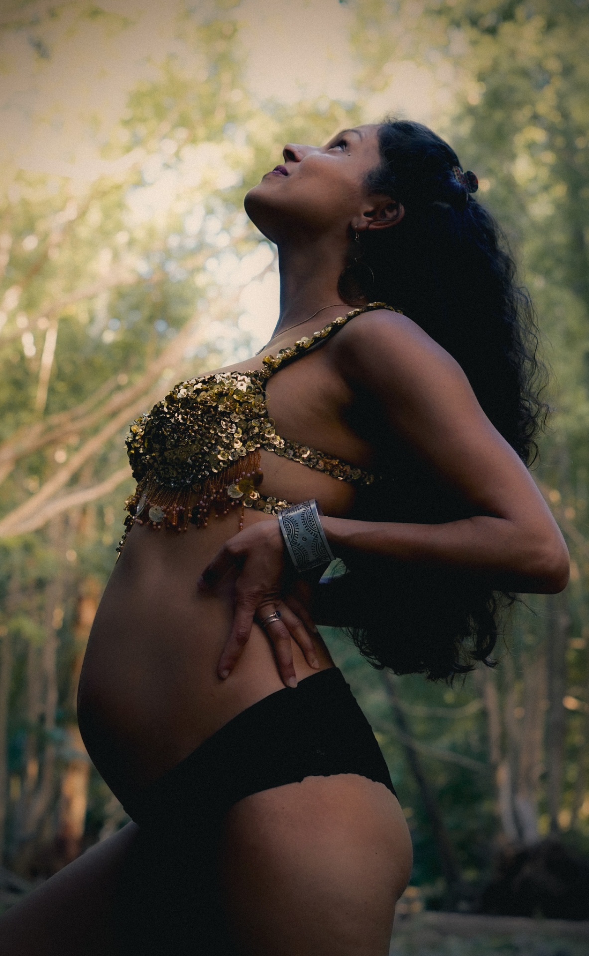Maternity portrait in the forest with soft upward gaze