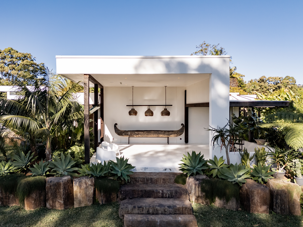 White pavilion framed by agaves and palms
